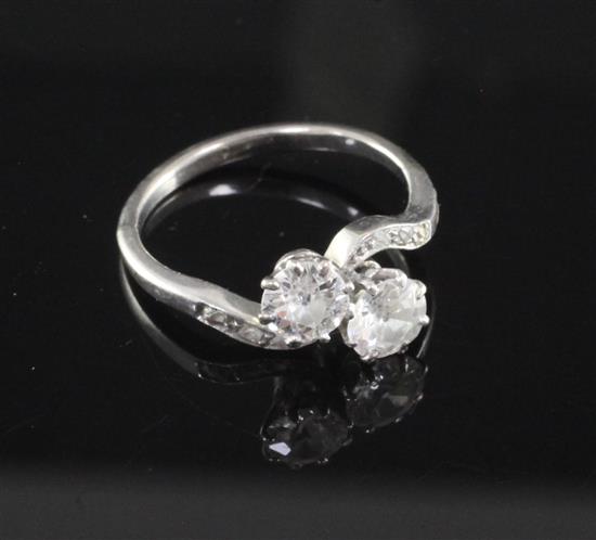 A platinum and two stone diamond crossover ring with diamond set shoulders, size K.